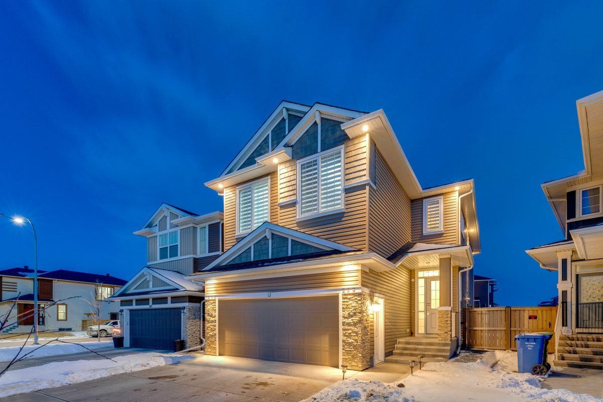 A two-storey family home lit up at dusk
